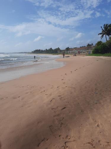a beach with footprints in the sand and the ocean at Neue Villa Wunderschön in Bentota