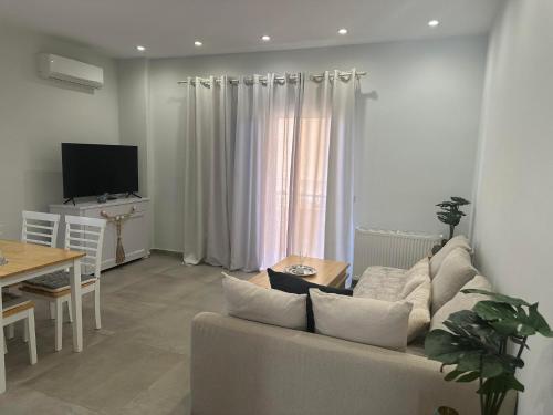 uma sala de estar com um sofá e uma mesa em Mimozas Apartment Porto Heli em Porto Heli