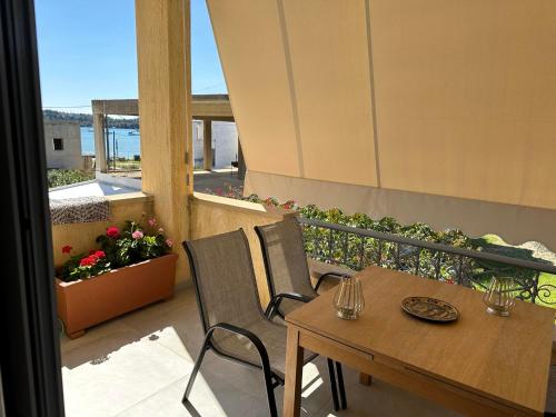 stół i krzesła na balkonie z widokiem w obiekcie Mimozas Apartment Porto Heli w mieście Porto Heli