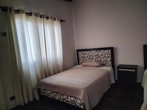 a bedroom with a bed and a large window at HOSTEL BRISAS in Torotoro