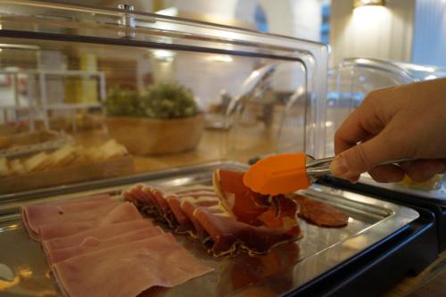 a person is cutting a sandwich with a knife at Hotel Villa Frigiliana in Frigiliana
