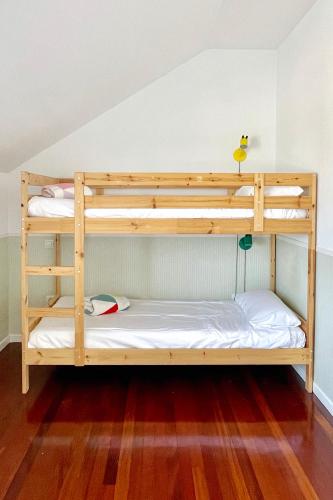 two bunk beds in a room with wood floors at Casita con preciosas vistas a la montaña in Boó de Piélagos