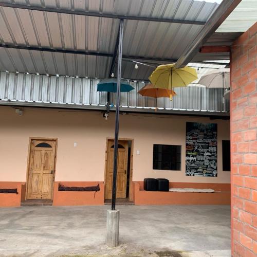 Zwei Regenschirme hängen von einem Gebäude in der Unterkunft Casa Campo Juive Grande in Riobamba