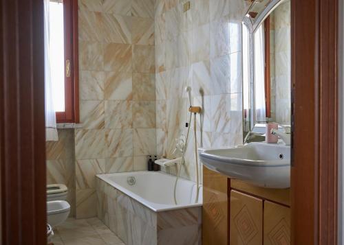 Tuscan ART DECO Villa ~ Countryside Home في ماسا: حمام مع حوض ومغسلة وحوض استحمام