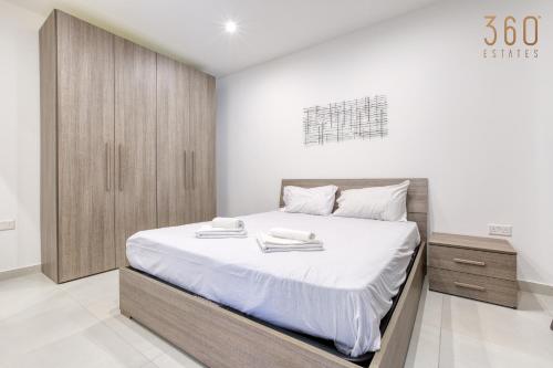 a bedroom with a large bed with white sheets at Modern 3BR home with Stunning Marina View in Pieta by 360 Estates in Tal-Pietà