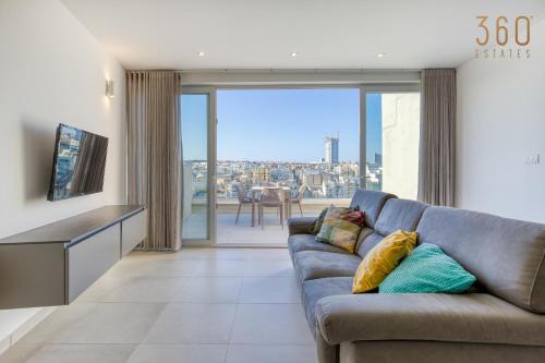 a living room with a couch and a large window at Modern 3BR home with Stunning Marina View in Pieta by 360 Estates in Tal-Pietà