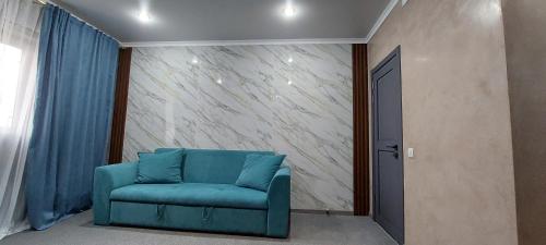 a blue chair in a room with a wall at EVFRAT-Q in Taraz