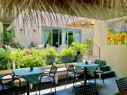a patio with two tables and chairs and plants at Hotel Alfieri in Sirmione