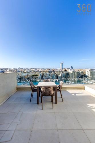 a table and chairs on a balcony with a view at Modern 3BR home with Stunning Marina View in Pieta by 360 Estates in Tal-Pietà