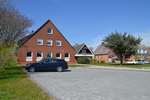 a blue car parked in front of a brick house at Haus Widder Nr3 in Kopendorf