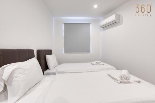 a white room with two beds and a window at Modern 3BR home with Stunning Marina View in Pieta by 360 Estates in Tal-Pietà