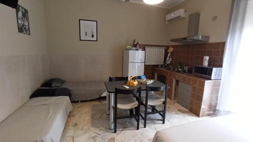 a small kitchen with a table and a refrigerator at Don Aurelio in città - 2 in Acireale