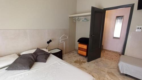 a bedroom with a bed and a door open at Don Aurelio in città - 2 in Acireale