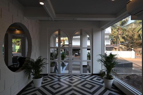 a lobby with glass doors and potted plants at Bedzzz Xclusiv Morjim, Goa By Leisure Hotels in Morjim