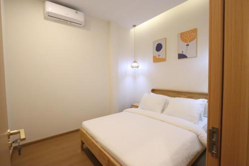 a bedroom with a bed with white sheets at Casabella 201 A2 Grand Batam Penuin Wet Market in Nagoya