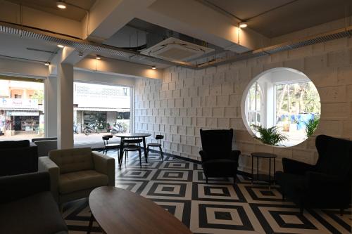 a waiting room with chairs and tables and a mirror at Bedzzz Xclusiv Morjim, Goa By Leisure Hotels in Morjim