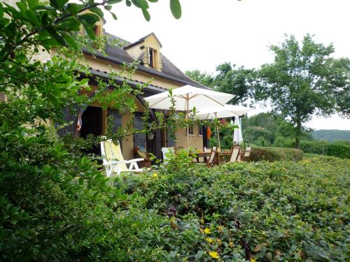 une maison avec une table et des chaises dans la cour dans l'établissement Les 10 Clés de Montfort/Piscine, à Vitrac