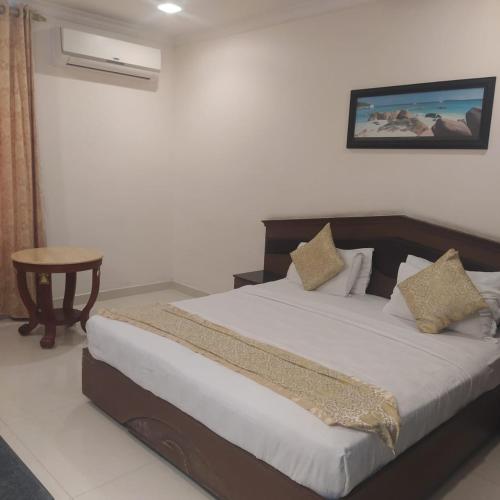 a bedroom with a bed and a table in it at THE SEASHORE HOTEL in Kanyakumari