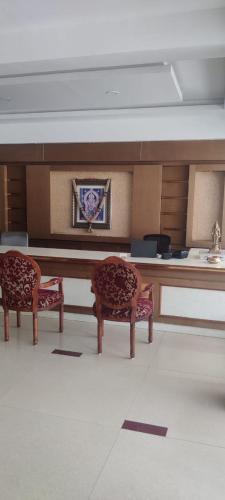 a living room with two chairs and a table at THE SEASHORE HOTEL in Kanyakumari