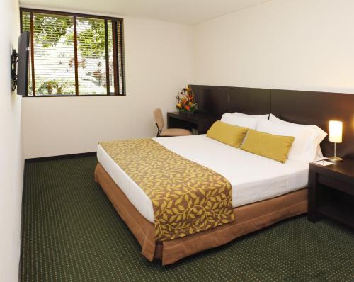 a bedroom with a large bed and a window at Estelar Recinto Del Pensamiento Hotel Y Centro De Convenciones in Manizales