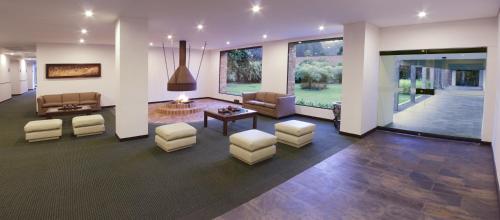 a lobby with couches and chairs and a table at Estelar Recinto Del Pensamiento Hotel Y Centro De Convenciones in Manizales