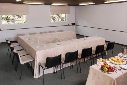 a conference room with tables and chairs with plates of food at Estelar Recinto Del Pensamiento Hotel Y Centro De Convenciones in Manizales