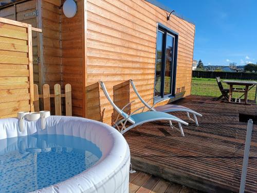 a deck with a hot tub and two chairs at Ecolodge du petit champ in Graves