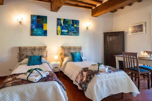 a bedroom with two beds and a table and a desk at La Dimora nell'Anfiteatro Superior room and apartment Self check in Elevator Air Conditioning in Lucca