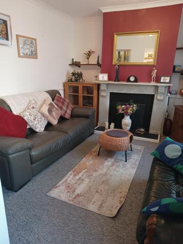 a living room with a couch and a fireplace at Cheerful 3-bedroom townhouse with free parking on site in Taunton