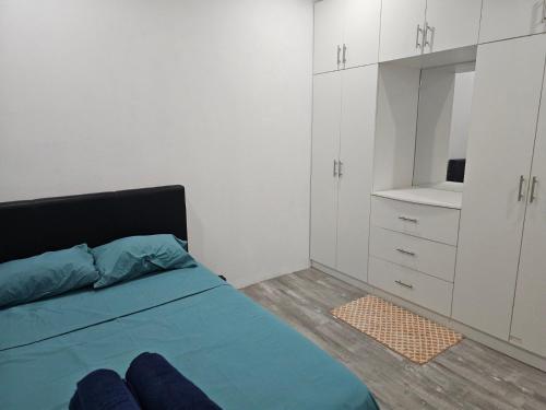 1 dormitorio con cama, armarios blancos y espejo en Moutain View Villa, en Pacific Harbour