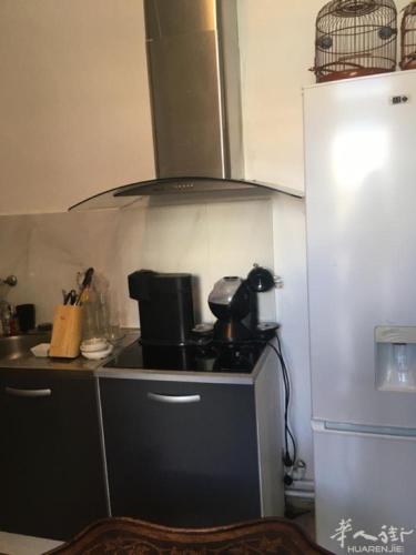 een keuken met een fornuis top oven naast een koelkast bij welcome you in Gennevilliers