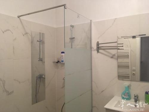 een witte badkamer met een douche en een wastafel bij welcome you in Gennevilliers