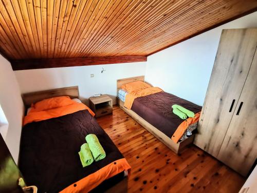 2 camas en una habitación con suelo de madera en Villa Stone Tree - Ljubanista, en Ohrid
