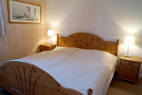 a bedroom with a large wooden bed with two lamps at Marinapark Scharmützelsee in Wendisch Rietz