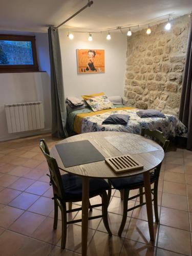 a bedroom with a table and a bed and a table and chairs at Studio ardéchois in Quintenas