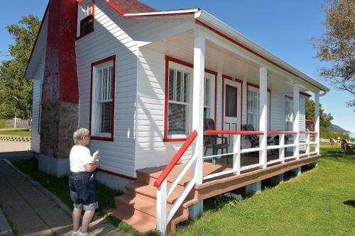 a woman standing in front of a tiny house at Motel et Chalets Bo-Fleuve Evangeline in Saint-Siméon