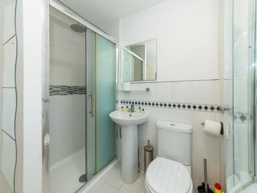 a bathroom with a toilet and a shower and a sink at Spacious Home with Modern Amenities Near IKEA Pass the Keys in Reading