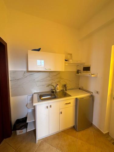 a small kitchen with a sink and a refrigerator at Evita's House in Lukovë