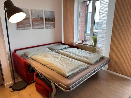 uma cama num quarto ao lado de uma janela em Watt & Wind - Tolles Schwimmbad em Cuxhaven