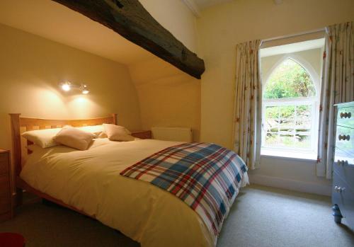 a bedroom with a large bed and a window at Penwaun Nevern in Nevern