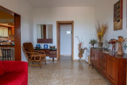 a living room with a red couch and a table at Spiti Damianos Villa Beachfront in Pomos