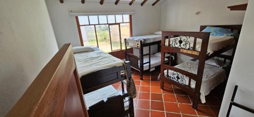 Habitación con varias literas y ventana. en Family Host HOSTEL en Villa de Leyva