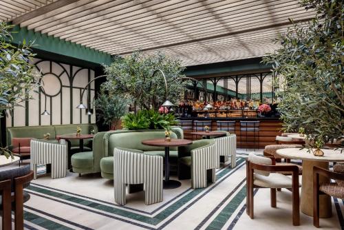restauracja ze stołami i krzesłami oraz bar w obiekcie TÓTEM Madrid, a Small Luxury Hotel of the World w Madrycie