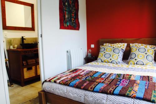 une chambre avec un lit avec une courtepointe colorée dessus dans l'établissement Le petit gîte de Cancale, Saint-Malo, Bretagne, à Cancale