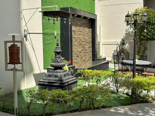 a statue in a garden in front of a building at Shakya House in Pātan