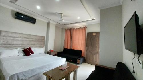 een hotelkamer met een bed en een stoel bij HOTEL MEDALLION EXPO in Lahore