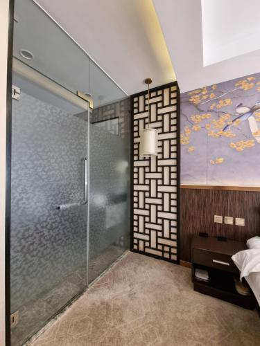 杜尚別的住宿－Friendship HOTEL，带淋浴的浴室和墙上的绘画