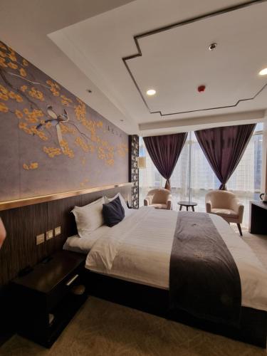 une chambre d'hôtel avec un lit et un mur orné d'une peinture dans l'établissement Friendship HOTEL, à Douchanbé