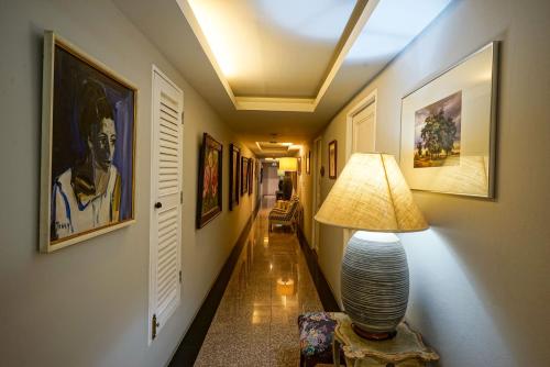a hallway with a lamp and paintings on the walls at At Pingnakorn Nimman Hotel in Chiang Mai