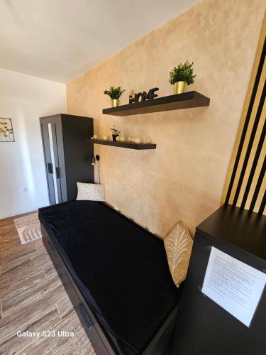 a room with a couch and shelves on the wall at Apartman Lena in Zrenjanin